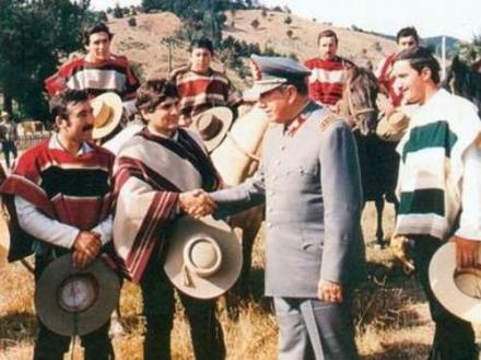 皮诺切特同身穿传统民族服饰的青年握手 皮诺切特同身穿传统民族服饰的青年握手